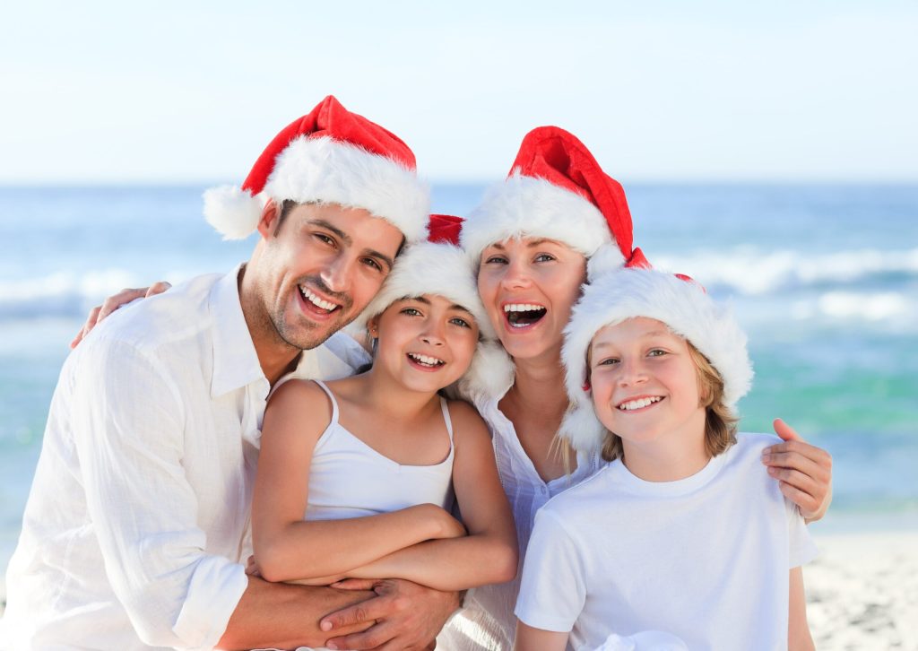 christmas stress, mental health tips. Pic of happy family wearing santa hats.