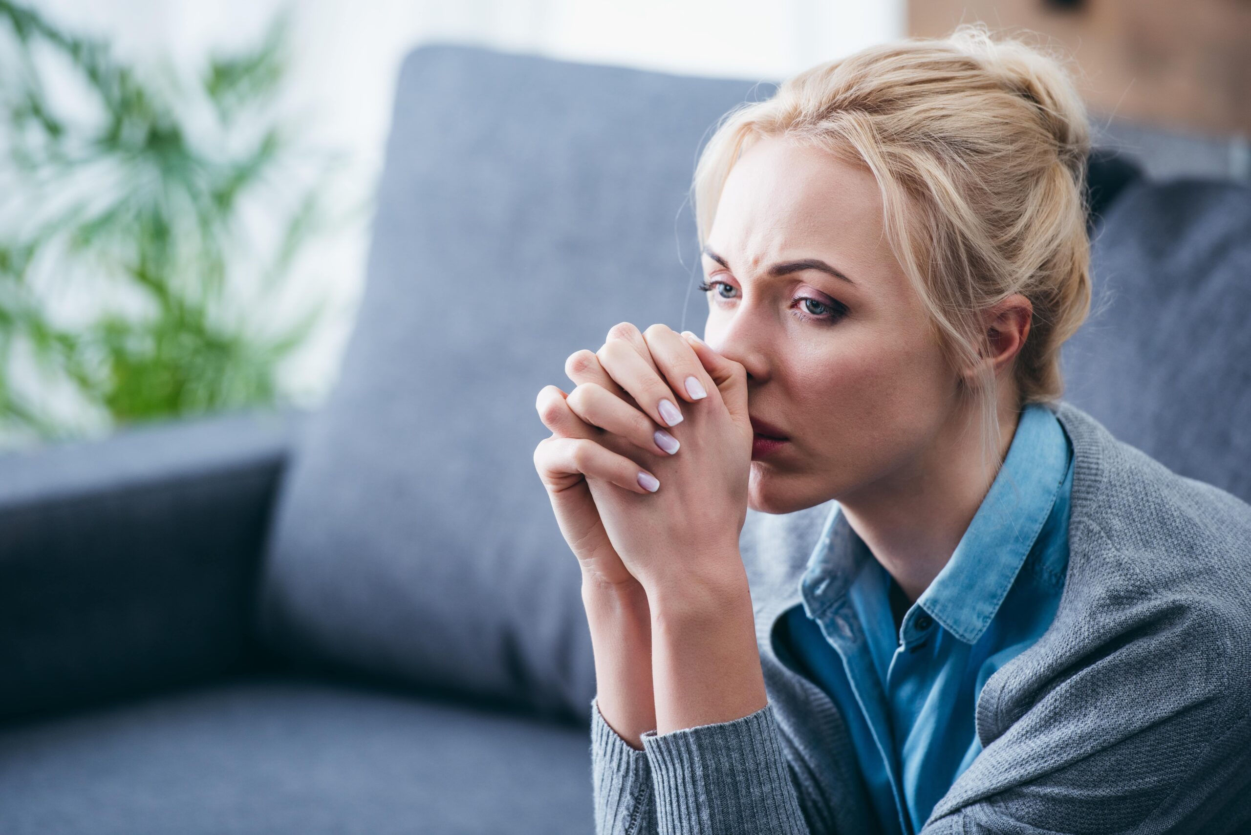 anxiety disorder, woman sitting on couch looking anxious
