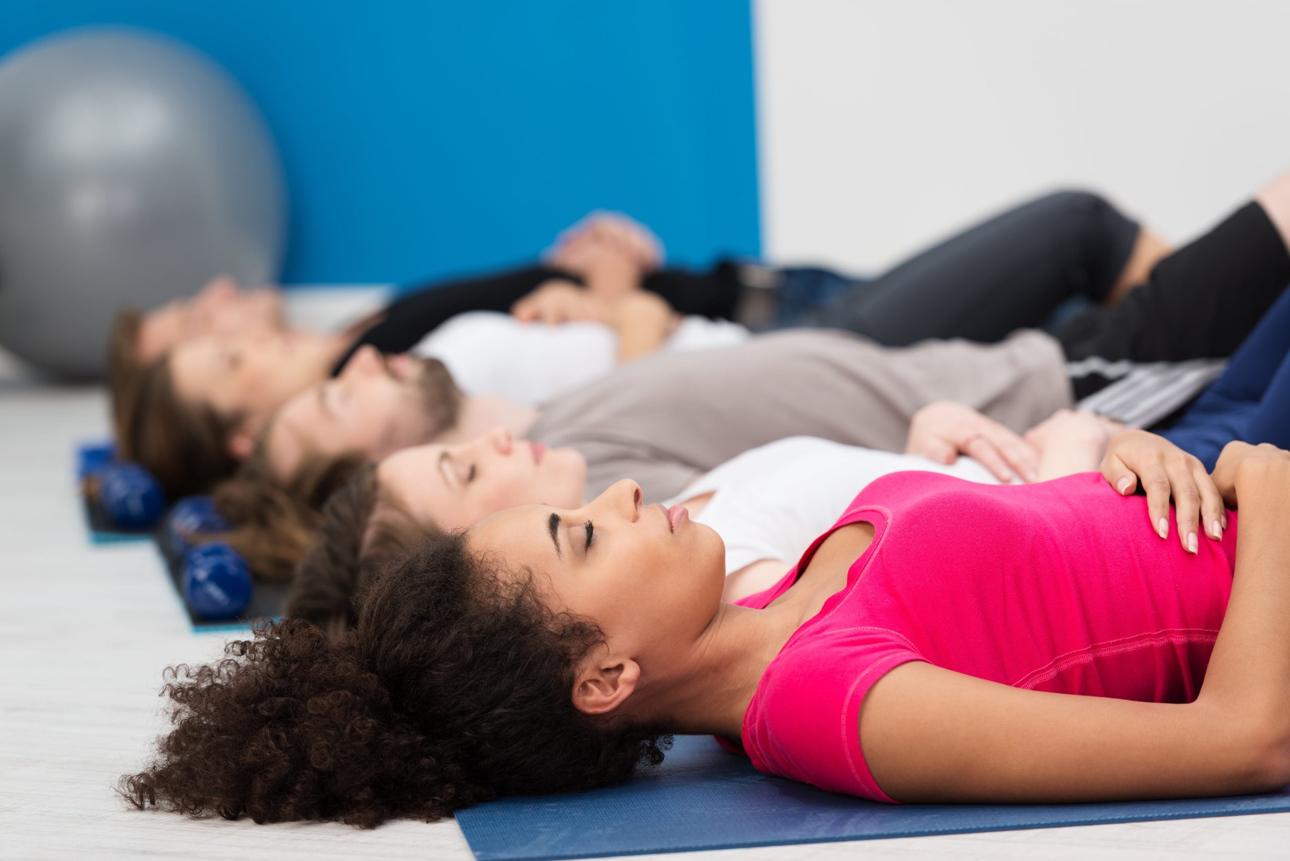 managing anxiety, three woman laying down at a yoga class 