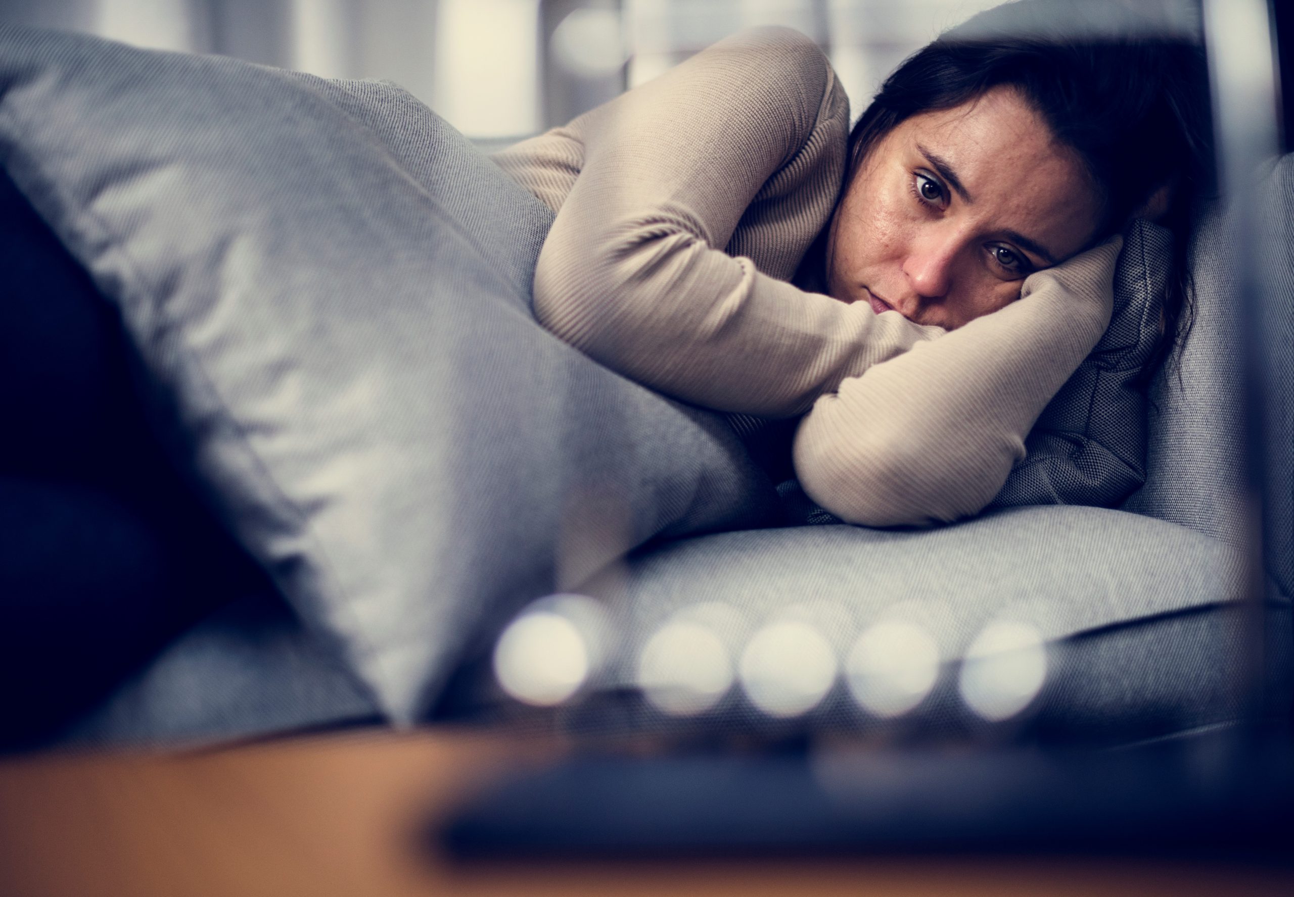 Managing Mental Health with a Chronic Illness 3 depressed woman, laying on bed looking sad