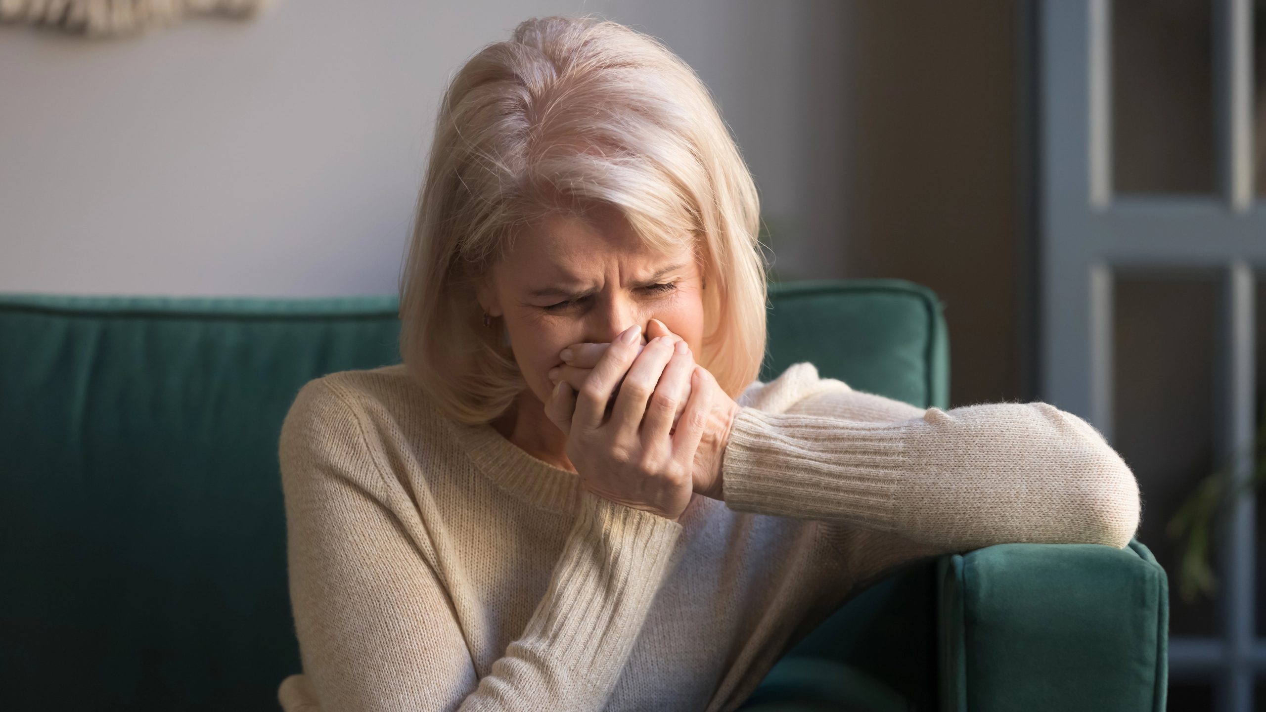 Dealing with the Death of Your Child 3 middle aged woman sitting on couch grieving