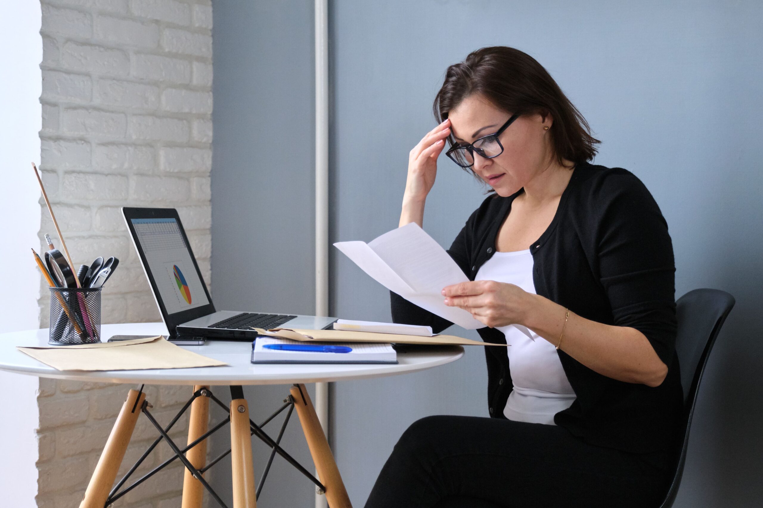 Work Stress, woman at desk working and looking stressed